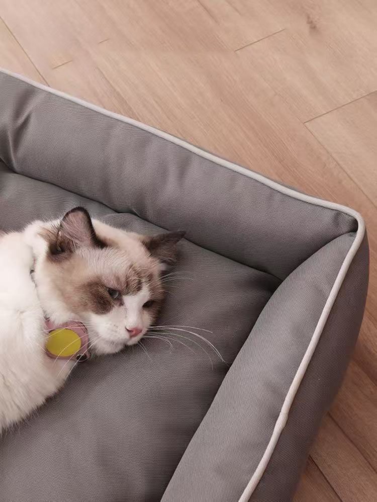 A ragdoll cat sleeping comfortably in a gray waterproof Oxford pet bed